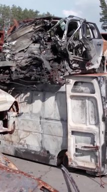 Bu stok dikey video Irpin, Bucha bölgesinde bir kurşun ve yanmış araba dökümü gösteriyor.