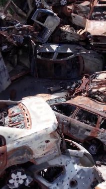 Bu stok dikey video Irpin, Bucha bölgesinde bir kurşun ve yanmış araba dökümü gösteriyor.