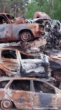 Bu stok dikey video Irpin, Bucha bölgesinde bir kurşun ve yanmış araba dökümü gösteriyor.