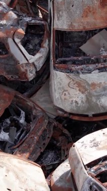 Bu stok dikey video Irpin, Bucha bölgesinde bir kurşun ve yanmış araba dökümü gösteriyor.