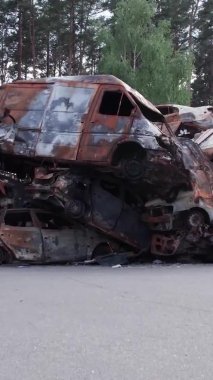 Bu stok dikey video Irpin, Bucha bölgesinde bir kurşun ve yanmış araba dökümü gösteriyor.
