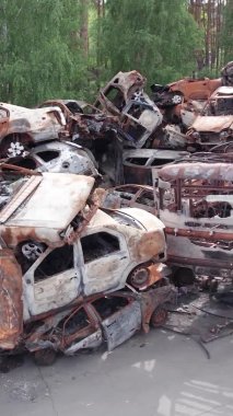 Bu stok dikey video Irpin, Bucha bölgesinde bir kurşun ve yanmış araba dökümü gösteriyor.