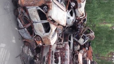 Bu stok dikey video Irpin, Bucha bölgesinde bir kurşun ve yanmış araba dökümü gösteriyor.