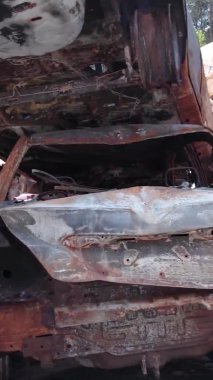 Bu stok dikey video Irpin, Bucha bölgesinde bir kurşun ve yanmış araba dökümü gösteriyor.