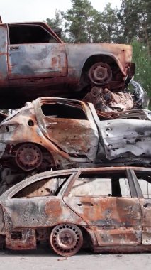 Bu stok dikey video Irpin, Bucha bölgesinde bir kurşun ve yanmış araba dökümü gösteriyor.