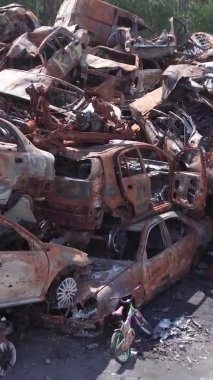 Bu stok dikey video Irpin, Bucha bölgesinde bir kurşun ve yanmış araba dökümü gösteriyor.