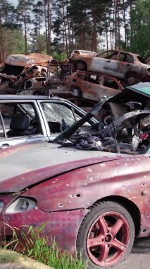 Bu stok dikey video Irpin, Bucha bölgesinde bir kurşun ve yanmış araba dökümü gösteriyor.