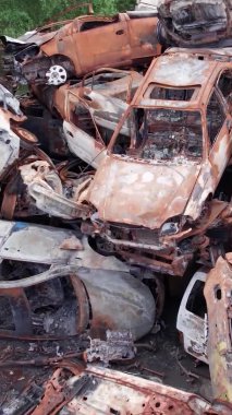 Bu stok dikey video Irpin, Bucha bölgesinde bir kurşun ve yanmış araba dökümü gösteriyor.