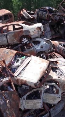 Bu stok dikey video Irpin, Bucha bölgesinde bir kurşun ve yanmış araba dökümü gösteriyor.