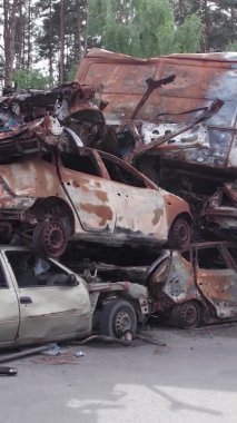 Bu stok dikey video Irpin, Bucha bölgesinde bir kurşun ve yanmış araba dökümü gösteriyor.