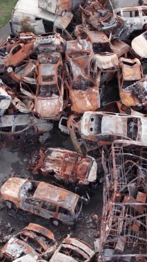 Bu stok dikey video Irpin, Bucha bölgesinde bir kurşun ve yanmış araba dökümü gösteriyor.