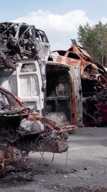 Bu stok dikey video Irpin, Bucha bölgesinde bir kurşun ve yanmış araba dökümü gösteriyor.