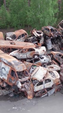 Bu stok dikey video Irpin, Bucha bölgesinde bir kurşun ve yanmış araba dökümü gösteriyor.