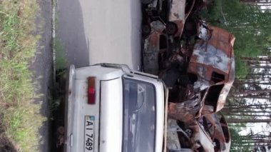 Bu stok dikey video Irpin, Bucha bölgesinde bir kurşun ve yanmış araba dökümü gösteriyor.