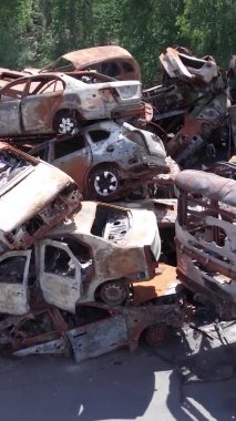 Bu stok dikey video Irpin, Bucha bölgesinde bir kurşun ve yanmış araba dökümü gösteriyor.