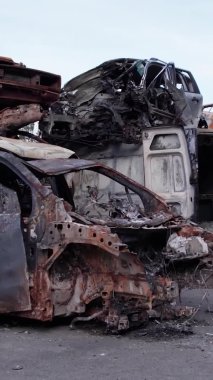 Bu stok dikey video Irpin, Bucha bölgesinde bir kurşun ve yanmış araba dökümü gösteriyor.