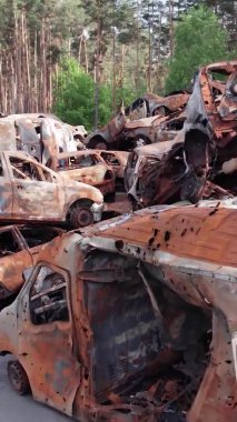 Bu stok dikey video Irpin, Bucha bölgesinde bir kurşun ve yanmış araba dökümü gösteriyor.