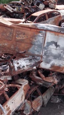 Bu stok dikey video Irpin, Bucha bölgesinde bir kurşun ve yanmış araba dökümü gösteriyor.