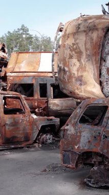 Bu stok dikey video Irpin, Bucha bölgesinde bir kurşun ve yanmış araba dökümü gösteriyor.