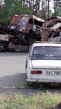Bu stok dikey video Irpin, Bucha bölgesinde bir kurşun ve yanmış araba dökümü gösteriyor.