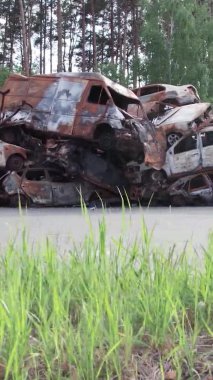 Bu stok dikey video Irpin, Bucha bölgesinde bir kurşun ve yanmış araba dökümü gösteriyor.