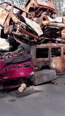 Bu stok dikey video Irpin, Bucha bölgesinde bir kurşun ve yanmış araba dökümü gösteriyor.