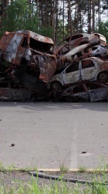 Bu stok dikey video Irpin, Bucha bölgesinde bir kurşun ve yanmış araba dökümü gösteriyor.