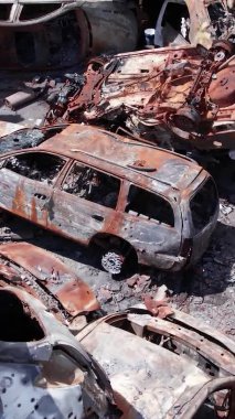 Bu stok dikey video Irpin, Bucha bölgesinde bir kurşun ve yanmış araba dökümü gösteriyor.