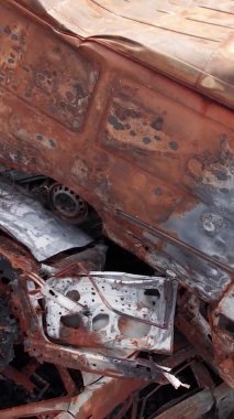 Bu stok dikey video Irpin, Bucha bölgesinde bir kurşun ve yanmış araba dökümü gösteriyor.