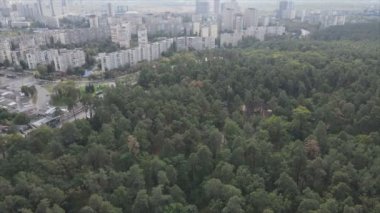 This stock footage shows an aerial view of the border of a forest and a big city, Kyiv, Ukraine in 8K resolution