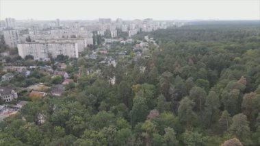 This stock footage shows an aerial view of the border of a forest and a big city, Kyiv, Ukraine in 8K resolution