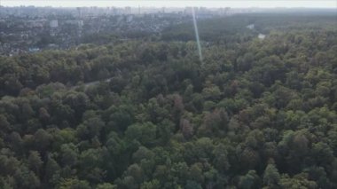 This stock footage shows an aerial view of the border of a forest and a big city, Kyiv, Ukraine in 8K resolution
