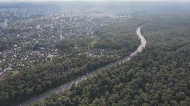 This stock footage shows an aerial view of the border of a forest and a big city, Kyiv, Ukraine in 8K resolution