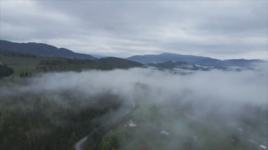 This stock footage shows aerial view of mountains covered with fog - Carpathians, Ukraine in 8K resolution