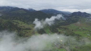 This stock footage shows aerial view of mountains covered with fog - Carpathians, Ukraine in 8K resolution