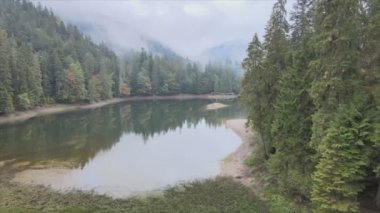 This stock video shows an aerial view of Synevyr Lake in the Carpathian Mountains, Ukraine in 8K resolution
