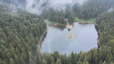 This stock video shows an aerial view of Synevyr Lake in the Carpathian Mountains, Ukraine in 8K resolution
