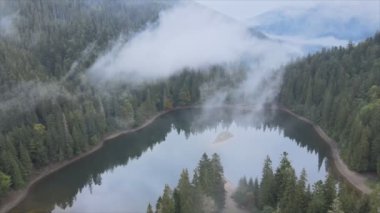 This stock video shows an aerial view of Synevyr Lake in the Carpathian Mountains, Ukraine in 8K resolution