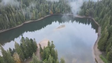 This stock video shows an aerial view of Synevyr Lake in the Carpathian Mountains, Ukraine in 8K resolution