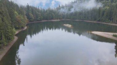This stock video shows an aerial view of Synevyr Lake in the Carpathian Mountains, Ukraine in 8K resolution