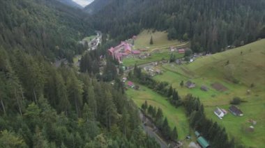 This stock footage shows aerial view of a small village in the forest in the Carpathians, Ukraine in 8K resolution
