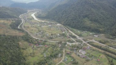This stock footage shows aerial view of a small village in the forest in the Carpathians, Ukraine in 8K resolution