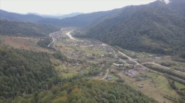 This stock footage shows aerial view of a small village in the forest in the Carpathians, Ukraine in 8K resolution