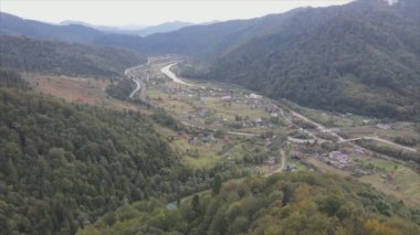 This stock footage shows aerial view of a small village in the forest in the Carpathians, Ukraine in 8K resolution