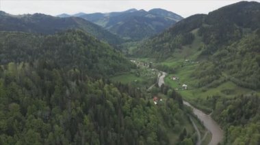 This stock footage shows aerial view of a small village in the forest in the Carpathians, Ukraine in 8K resolution