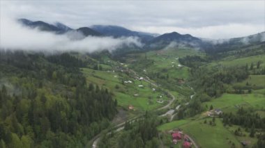 This stock footage shows aerial view of a small village in the forest in the Carpathians, Ukraine in 8K resolution