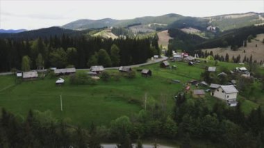 This stock footage shows aerial view of a small village in the forest in the Carpathians, Ukraine in 8K resolution