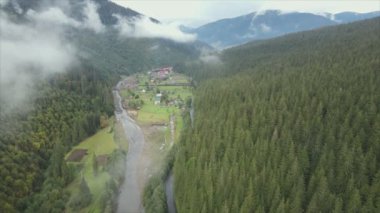 This stock footage shows aerial view of a small village in the forest in the Carpathians, Ukraine in 8K resolution