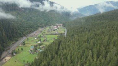 This stock footage shows aerial view of a small village in the forest in the Carpathians, Ukraine in 8K resolution