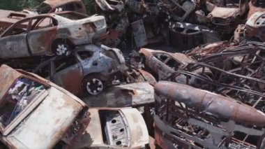 This stock video shows a dump of shot and burned cars in Irpin, Bucha district in 8K resolution
